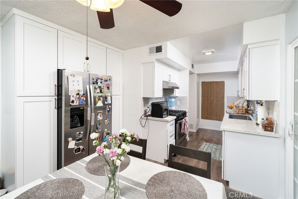 1800 West Gramercy Avenue, Unit 43 Anaheim, CA 92801 - Photo 11 of 34 a kitchen with stainless steel appliances kitchen island granite countertop a refrigerator and microwave