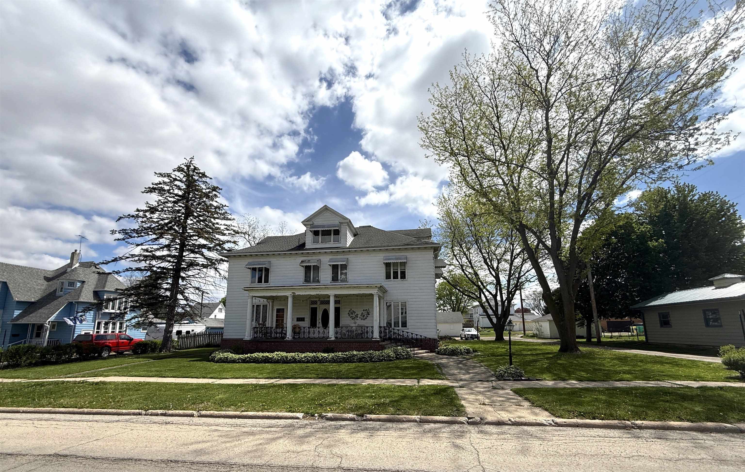 323 South Main Street Stockton, IL 61085 - Photo 3 of 32 a view of a big house with a big yard and large trees
