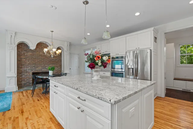 a kitchen with stainless steel appliances granite countertop a sink a oven and a refrigerator