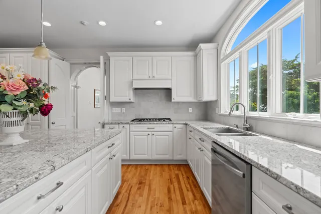 a kitchen with stainless steel appliances granite countertop a sink stove and cabinets