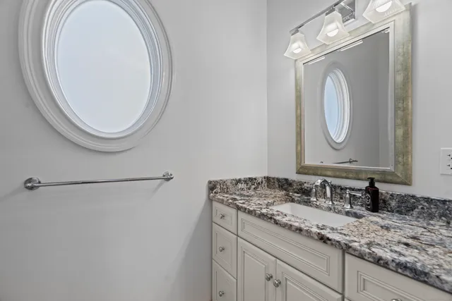a bathroom with a granite countertop double vanity sink and a mirror