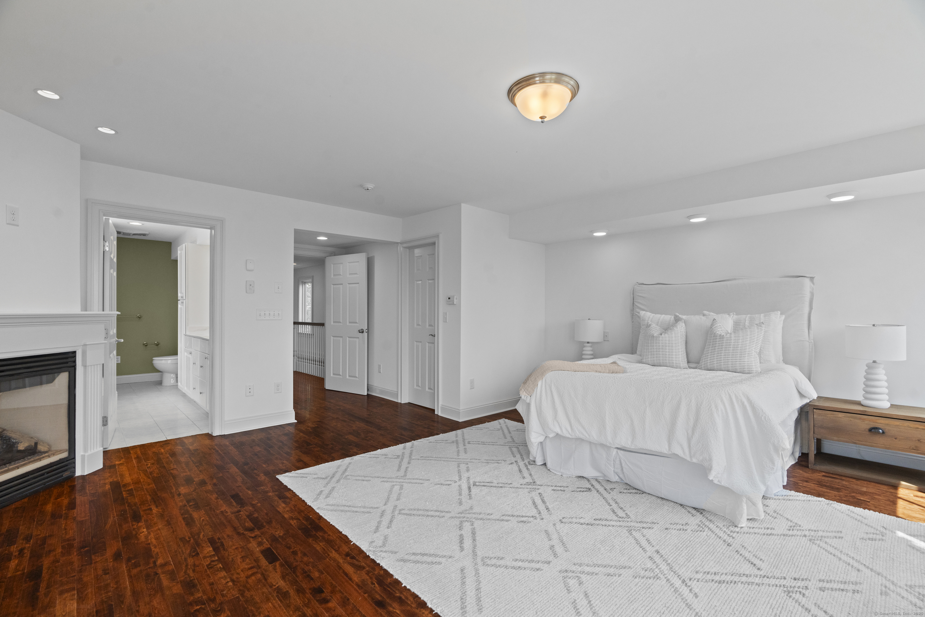 64 Webster Point Road Madison, CT 06443 - Photo 25 of 38 a spacious bedroom with a bed and a fireplace