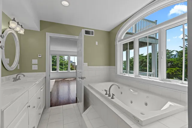 a bathroom with a tub sink and mirror