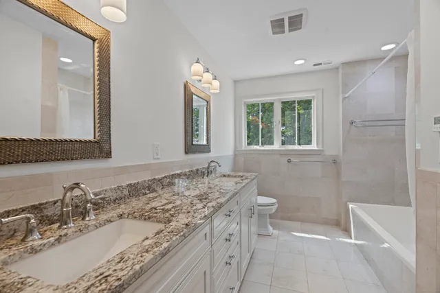 a bathroom with a granite countertop sink toilet and shower