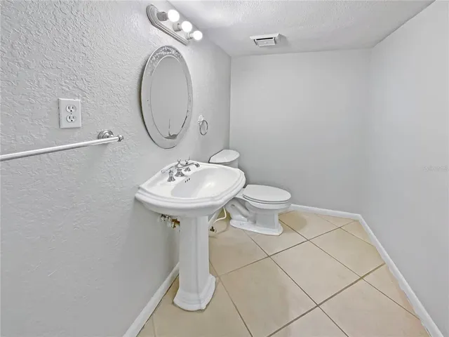 a bathroom with a sink toilet and a mirror