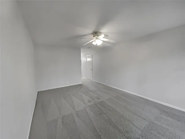 a view of an empty room with a ceiling fan
