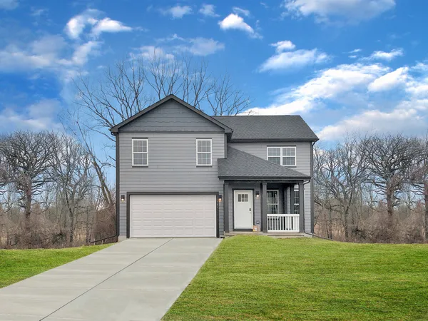 a front view of a house with yard and green space