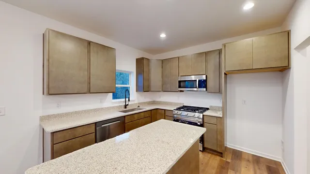 a kitchen with granite countertop a sink stove and refrigerator