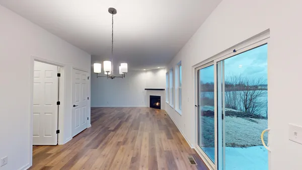 a view of a room with wooden floor fireplace and windows