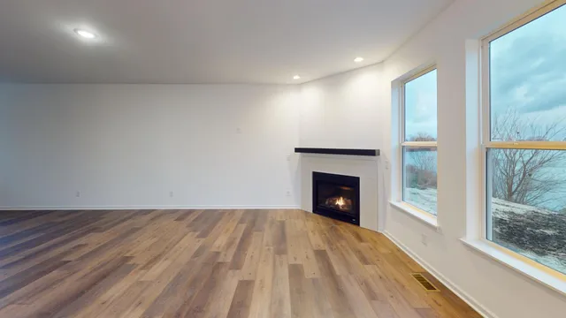 a view of an empty room with a window and a fireplace