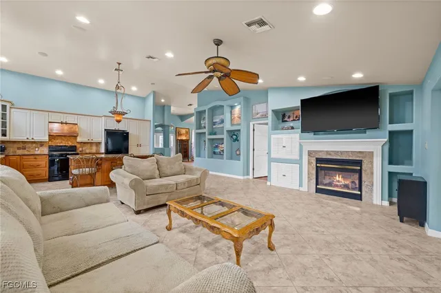 a spacious bedroom with a large bed a chandelier and a flat screen tv