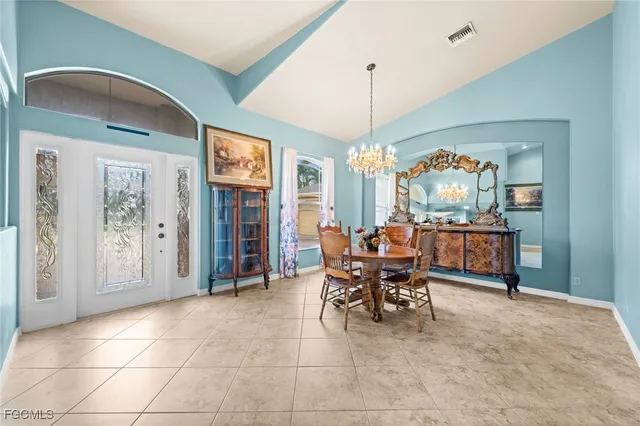 a dining room with furniture a chandelier and window