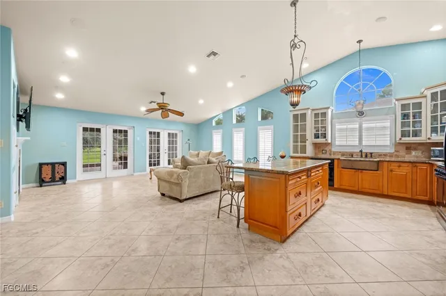 a living room with furniture kitchen view and a chandelier