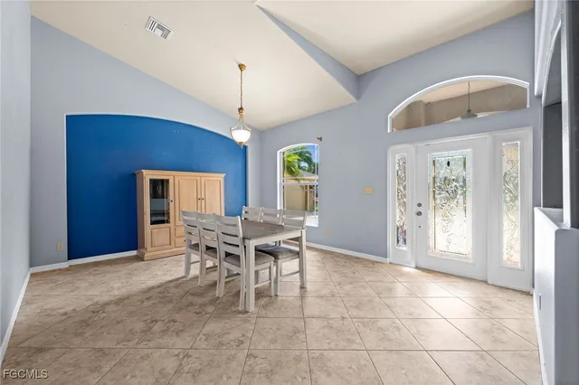 a dining room with wooden floor a chandelier a wooden table and chairs