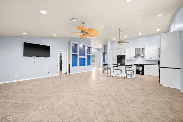 a view of kitchen with stainless steel appliances refrigerator oven and white cabinets with wooden floor
