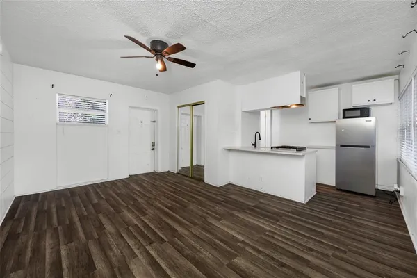 a view of empty room with wooden floor and window