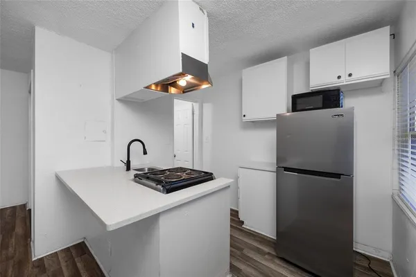 a kitchen with a stove and a wooden floor