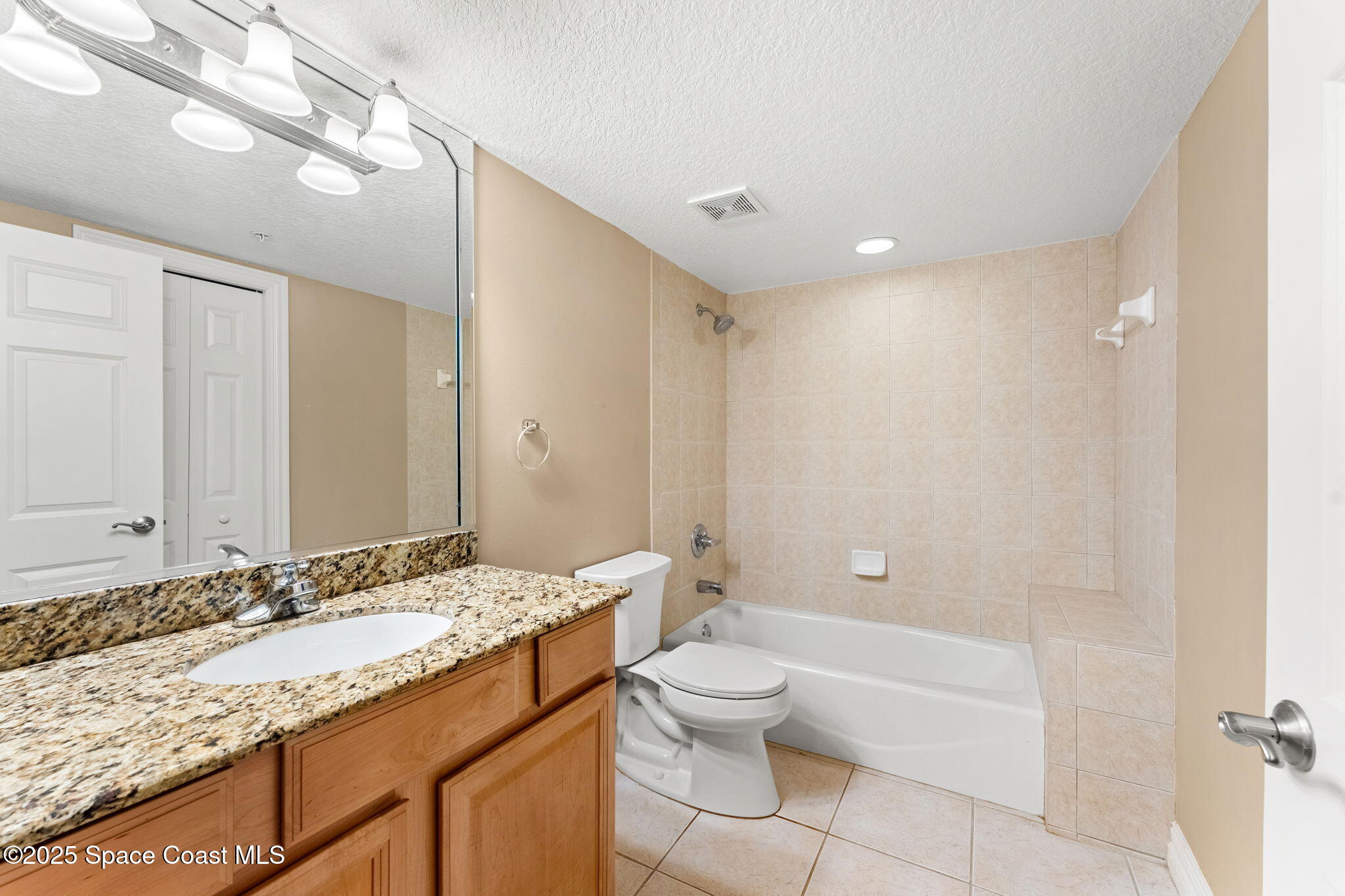 210 24th Street, Unit 201 Cocoa Beach, FL 32931 - Photo 19 of 41 a bathroom with a granite countertop sink a toilet and shower