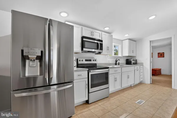 a kitchen with stainless steel appliances granite countertop a refrigerator sink and stove
