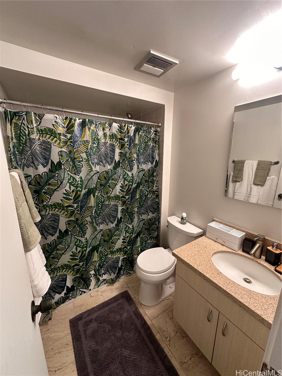 225 Queen Street, Unit 16A Honolulu, HI 96813 - Photo 11 of 16 a bathroom with a granite countertop sink a toilet a mirror and shower