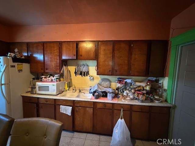 127 East 81st Street Los Angeles, CA 90003 - Photo 13 of 23 a room with stainless steel appliances kitchen island granite countertop furniture a sink and a refrigerator