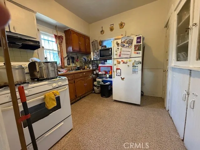 a kitchen with stainless steel appliances granite countertop a refrigerator a stove a sink and dishwasher