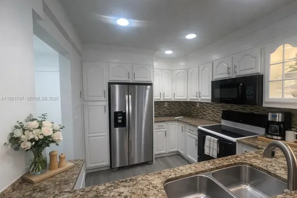 a kitchen that has a sink cabinets counter space and stainless steel appliances
