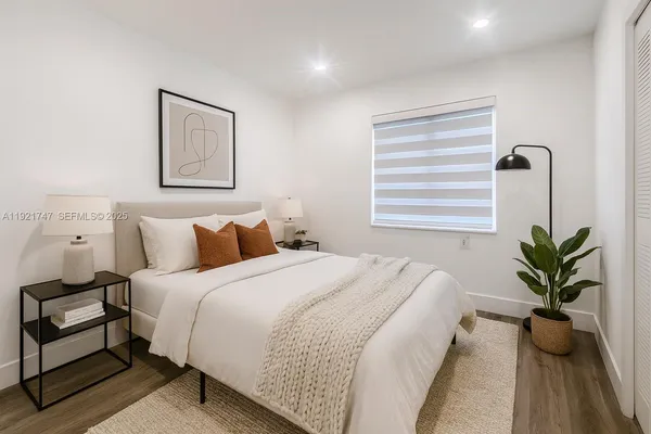 a bedroom with bed plant and window