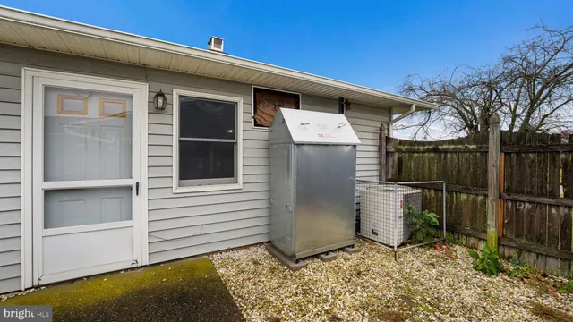a view of a small house with wooden fence