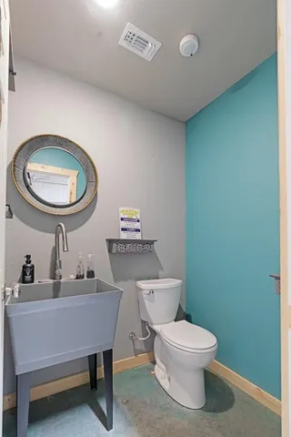 a bathroom with a toilet a sink and mirror
