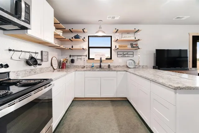a kitchen with stainless steel appliances kitchen island a table and chairs in it