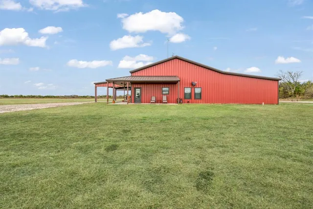 a large tree in front of a house with a yard