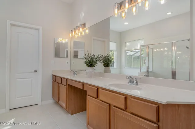 a bathroom with a sink double vanity granite tub shower and a mirror