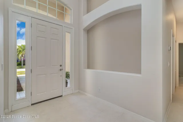 a view of an empty room with a window and a kitchen