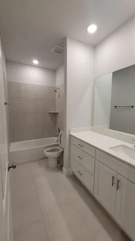 a bathroom with a double vanity sink toilet and shower