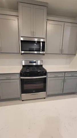 a kitchen with granite countertop a stove and a microwave