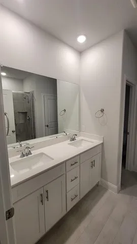 a bathroom with a double vanity sink and mirror