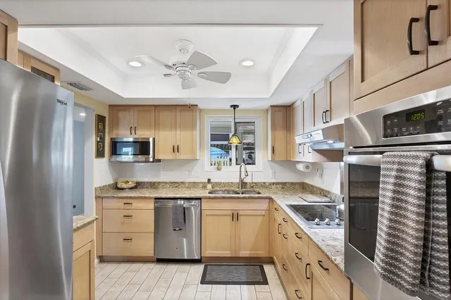 a kitchen with stainless steel appliances granite countertop a sink and cabinets