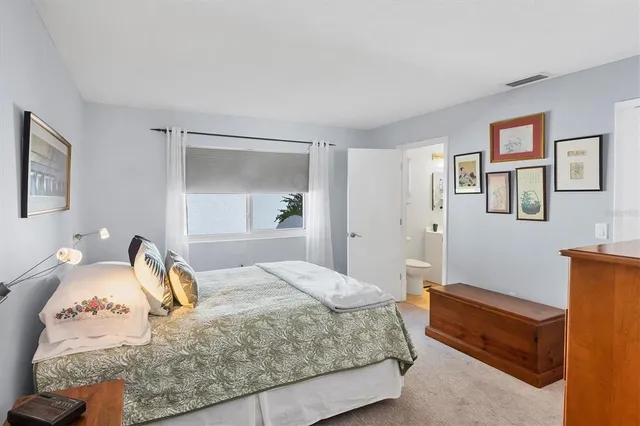 a bedroom with a bed and a painting on the wall