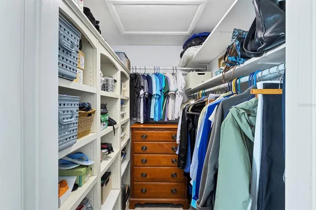 a view of walk in closet with clothes and shoes