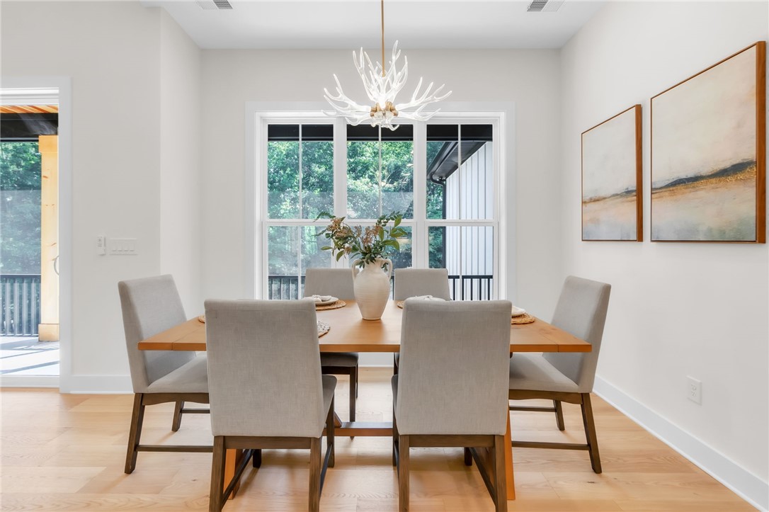 574 Paramount Drive Seneca, SC 29678 - Photo 15 of 45 A striking antler-inspired chandelier illuminates this bright dining area with views of lush greenery.