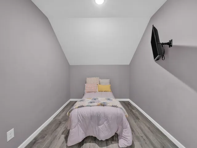 a bed sitting in a bedroom next to a wooden floor