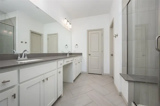 a large white kitchen with a sink and dishwasher a stove top oven with wooden floor