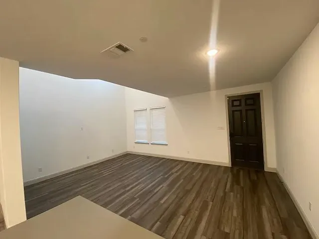 a view of a room with wooden floor and white walls
