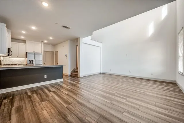 a view of kitchen with kitchen island wooden floors granite counter tops and a window