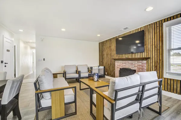 a living room with furniture a fireplace and a flat screen tv
