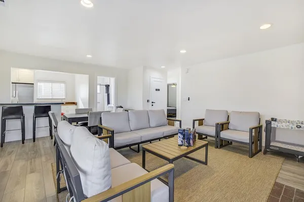 a living room with furniture and a dining table with wooden floor
