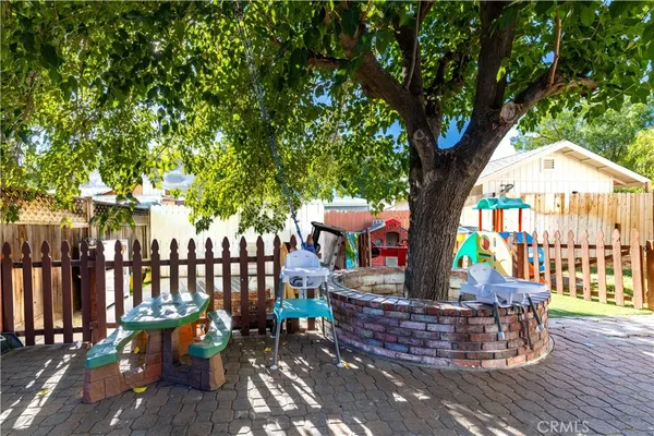 a view of a patio with table and chairs potted plants and a large tree