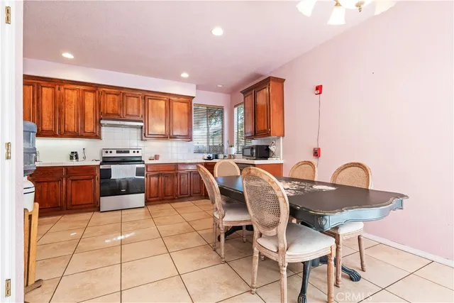 a kitchen with granite countertop a stove a sink a counter top space and cabinets