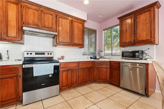 a kitchen with stainless steel appliances granite countertop a stove sink and cabinets